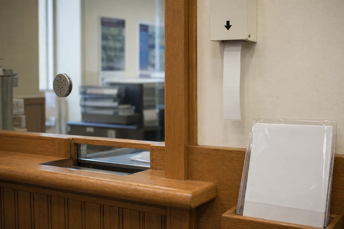 UK government service counter with documents and screen.